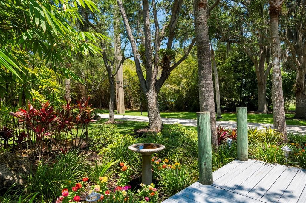 The meticulously landscaped grounds and gardens include a Waldenesque pond, mature Oak trees, Meyer lemon trees, Plumeria, Hibiscus, and orchids, creating a vibrant and colorful environment.