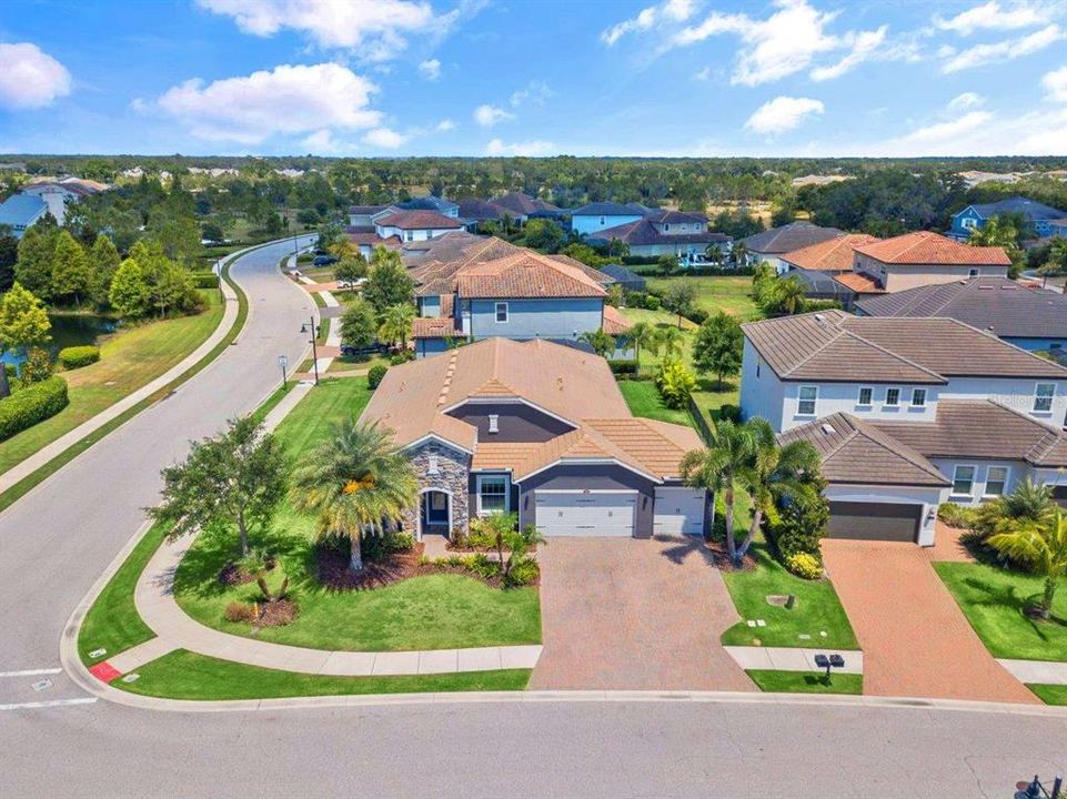 Aerial of the front elevation showing the home on a large corner lot.