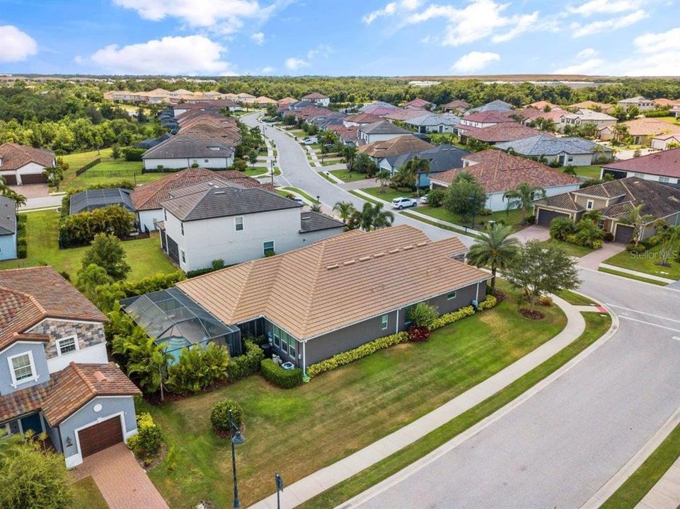 Aerial of the back of the home showing the side yard and corner lot.