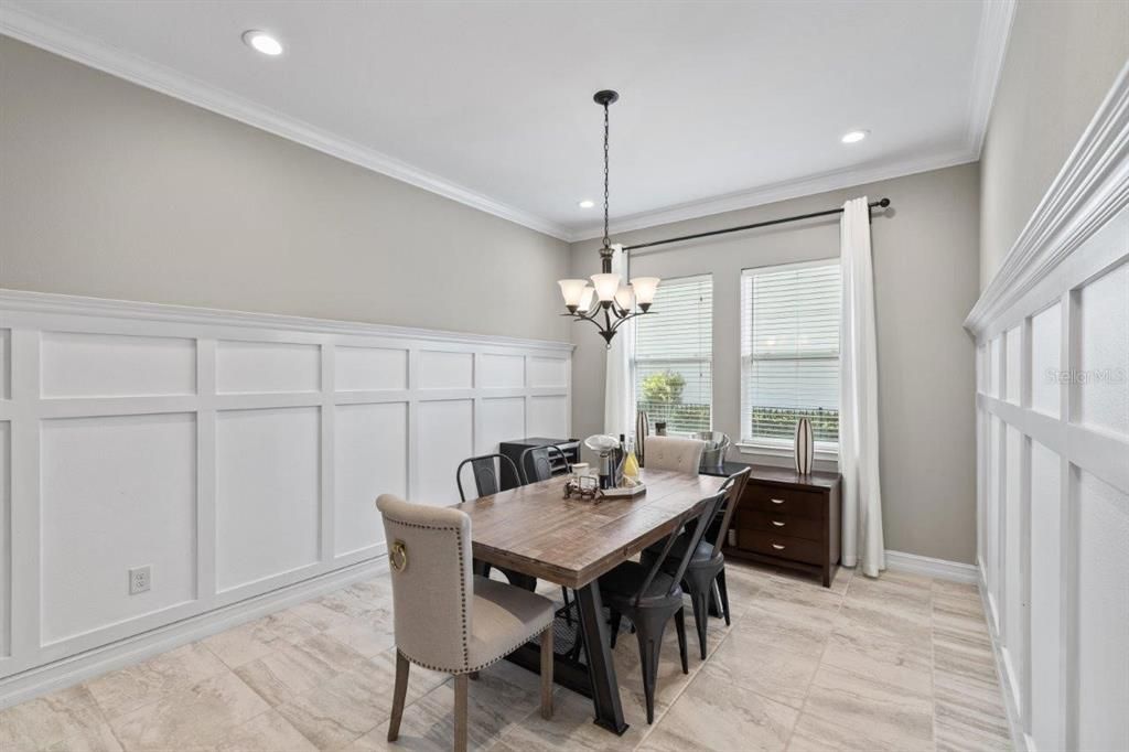 Dining room featuring wainscotting, and crown molding.