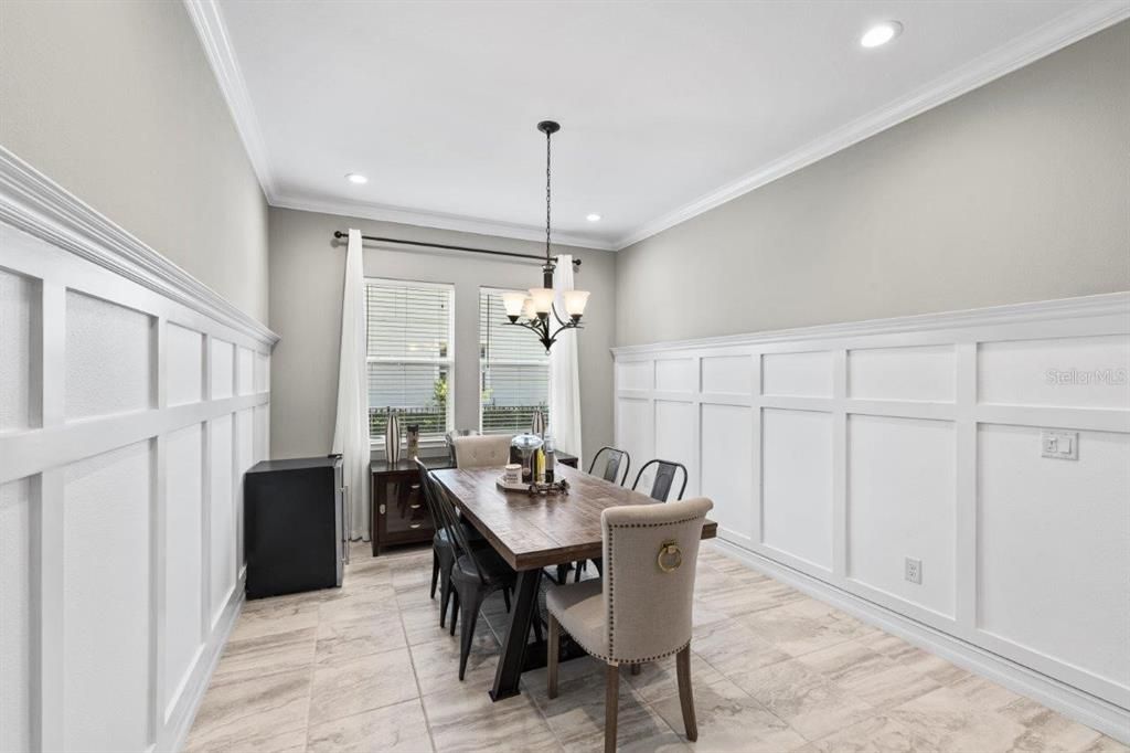 Dining room featuring wainscotting, and crown molding.