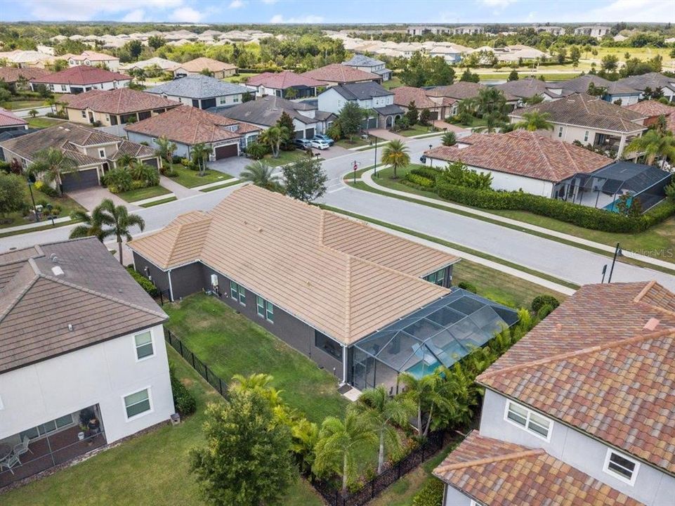 Aerial of the back of the home showing the fenced-in yard and screened-in lanai.