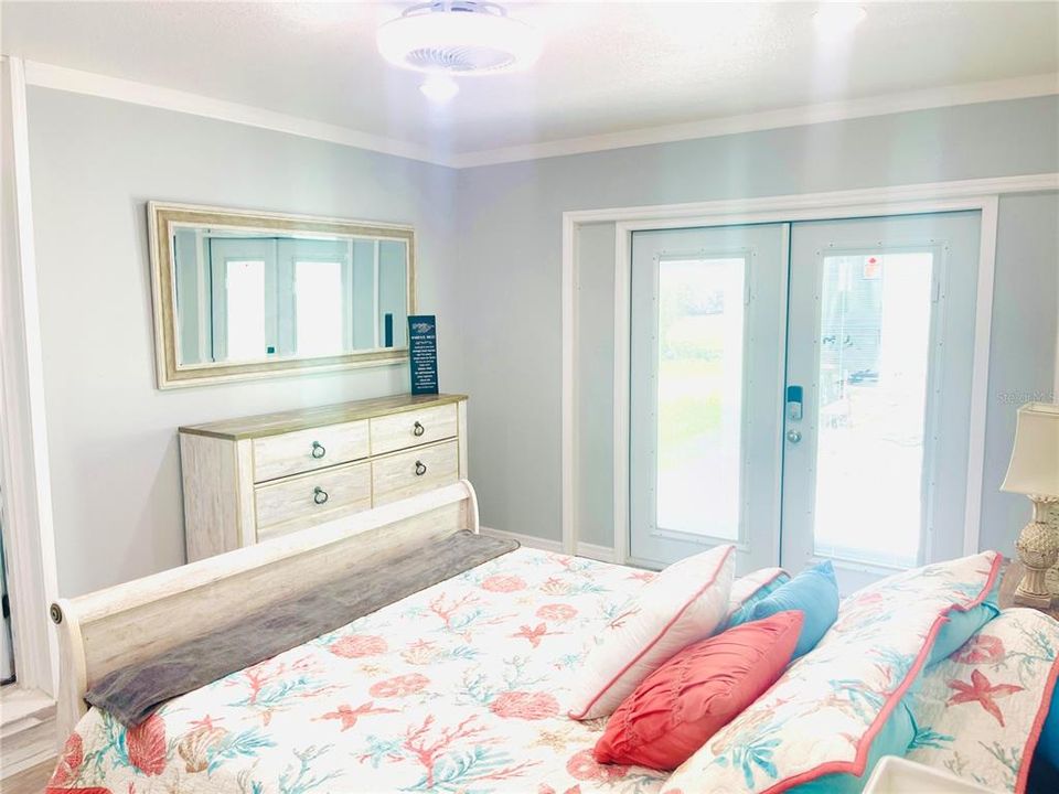 Primary Bedroom with new ceiling fan, and French doors that take you out to your patio