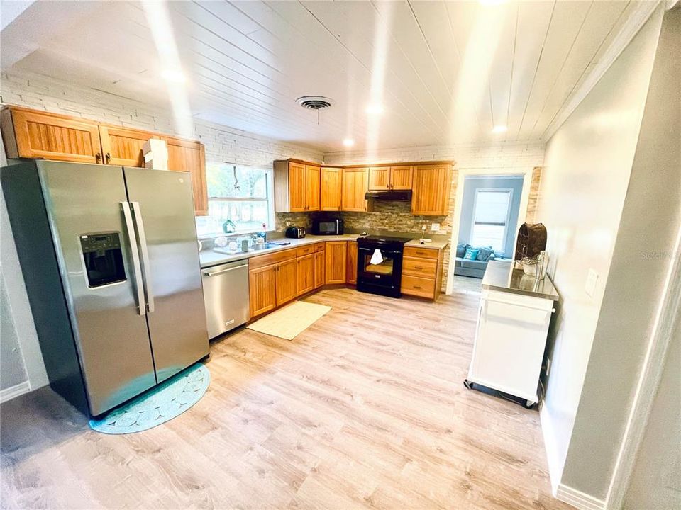 Enjoy your time cooking and baking in your Spacious, open kitchen with wood cabinets, solid surface counters, brand new stainless steel refrigerator, custom built-in cabinet features and a picturesque view of your private front yard awaits you.