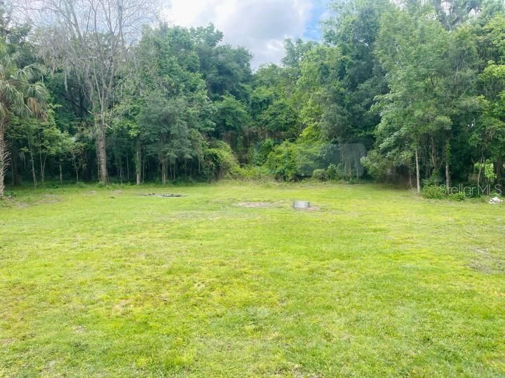 Relax on your 2.5 acres of tranquil tree-lined property with your cement block  NO FLOOD ZONE, NO HOA, NO DEED RESTRICTIONS, NO FLOOD ZONE home nestled in the center of this serene lush property.