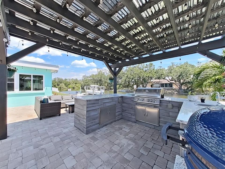 Enjoy cooking in your Outdoor Kitchen with tin-covered pergola and paver patio for lounging! Relax or entertain here!