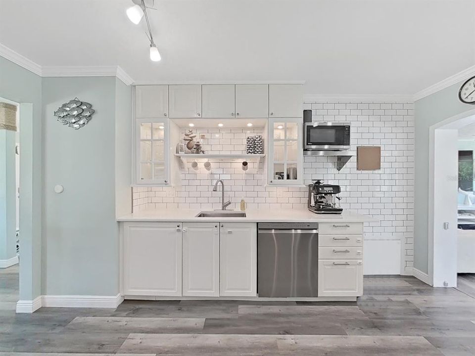 Timeless subway tile backsplash makes for easy-wipe surface. Stainless accents are nice touches and add to the coastal feel!