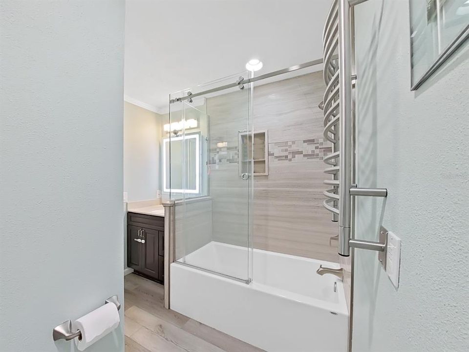 Primary Bath Tub/Shower with glass doors. Mounted towel warmer for cozy comfort!