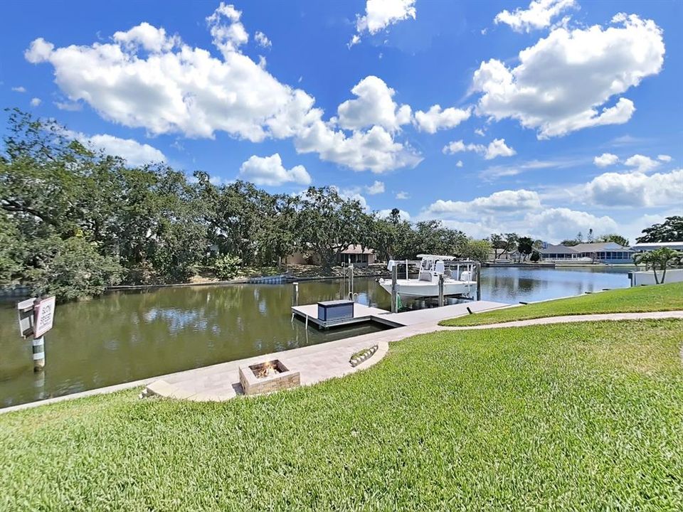 Waterfront with built-in fire pit area, composite dock with boat lift, water, and electric.