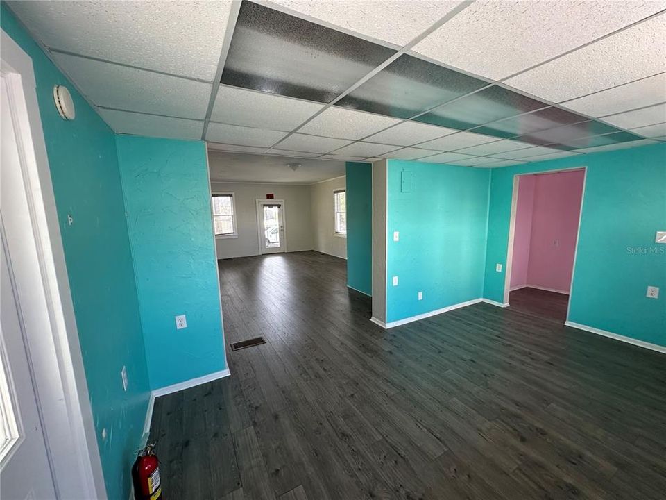 Interior view from back of space to front door / pink area is open storage with closet