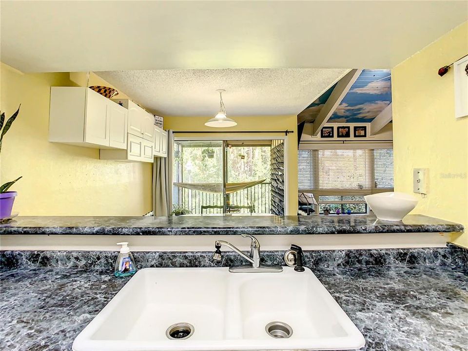 Kitchen looks into dining area and screened in porch