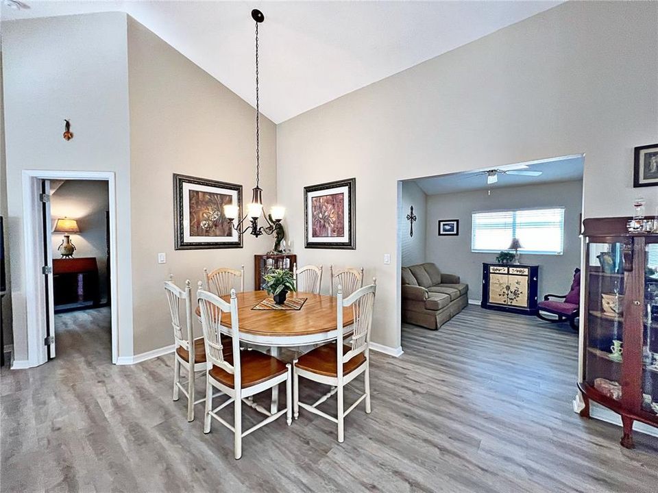 Additional view of kitchen with Eat in space, laminate flooring, and view of living room with stackable sliding glass doors