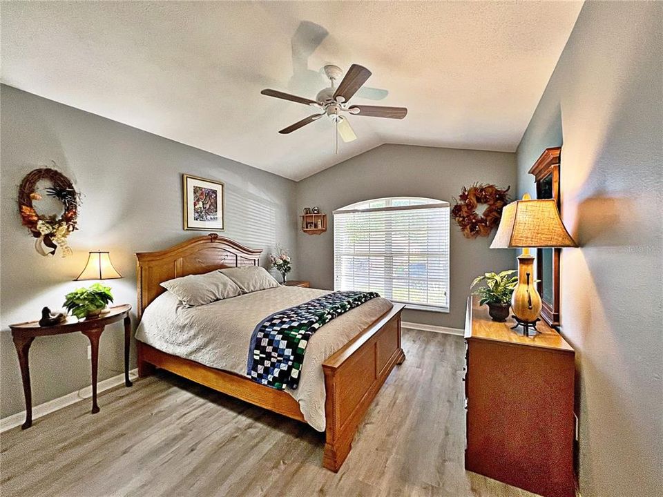 Additional view of bedroom two with laminate flooring, freshly painted ceiling, fan and landscape yard