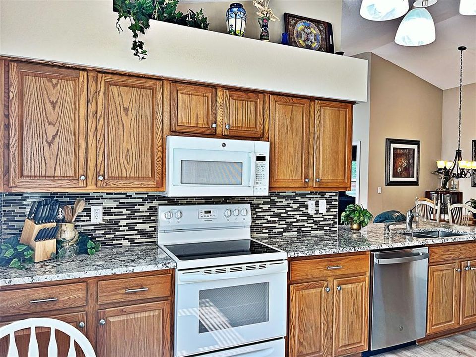 Kitchen with backsplash, newer appliances, freshly painted bar top seating