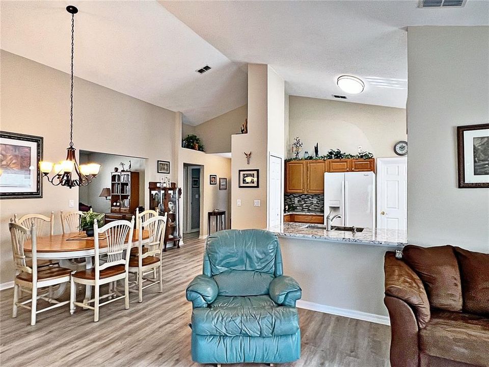 Additional view of living room and kitchen with entry, vaulted ceilings, decorative ship shelving