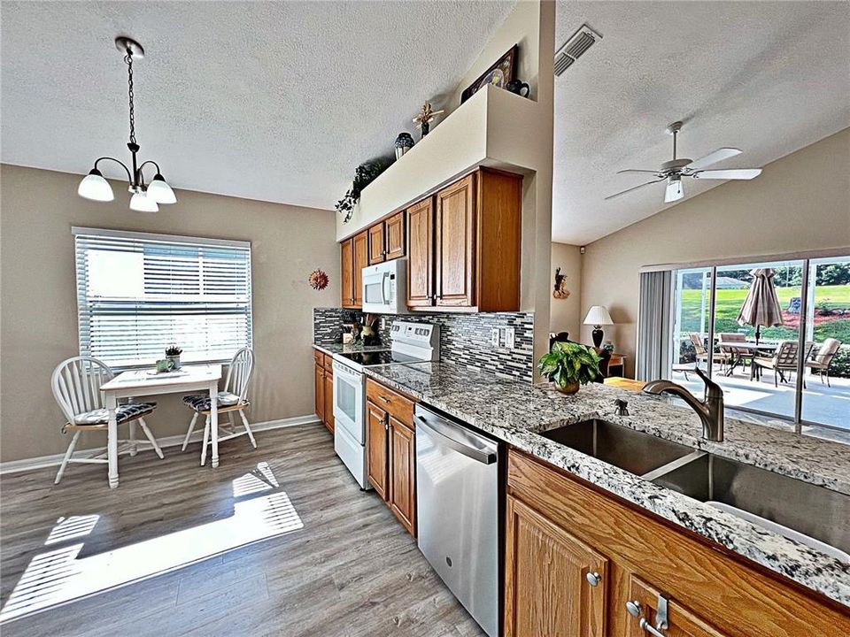 Kitchen with QUARTZ countertops, eat in dining area, new faucet, laminate flooring, decorative shelving