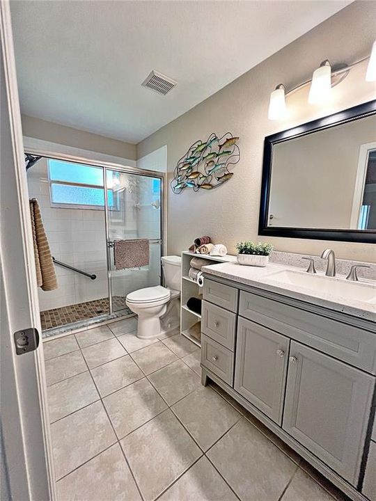 Master bathroom with shower, ceramic tile flooring, new vanity, and sink.