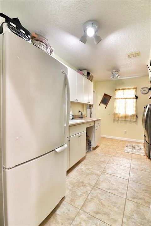 huge inside laundry room with an extra refrigerator and sink