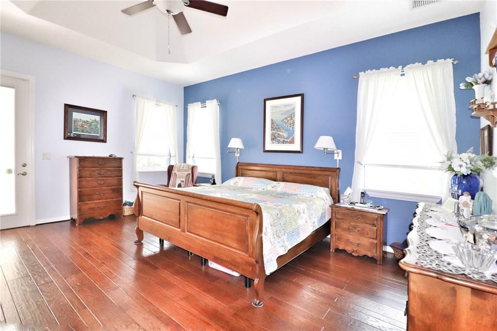 The spacious master bedroom has a tray ceiling