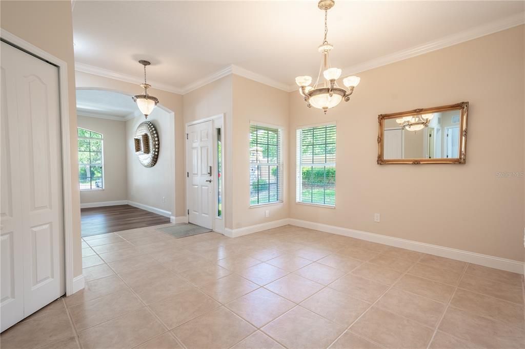 The Dining room features a decorative chandelier, crown molding and ceramic tile flooring.