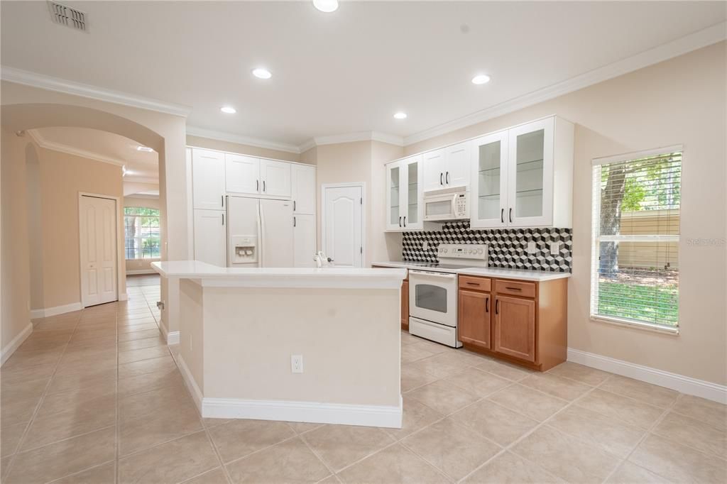 The kitchen features and island with  a double sink and a breakfast bar.