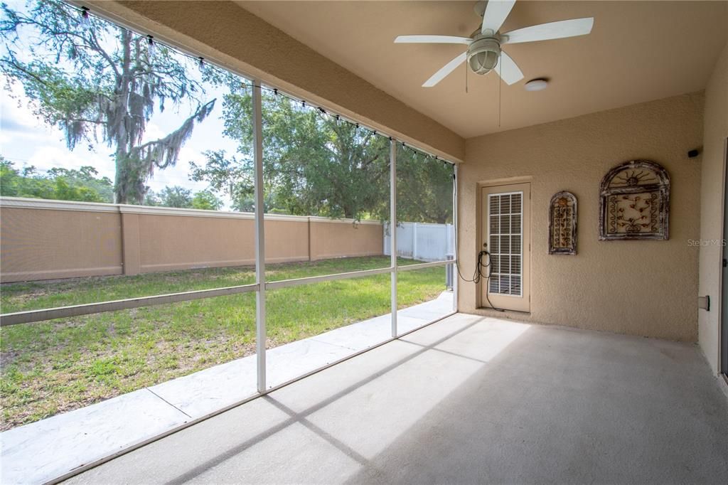 The screened in lanai features a ceiling fan for year round comfort