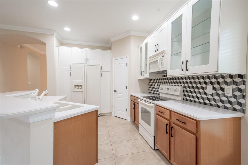 The kitchen features a stylish tile backsplash