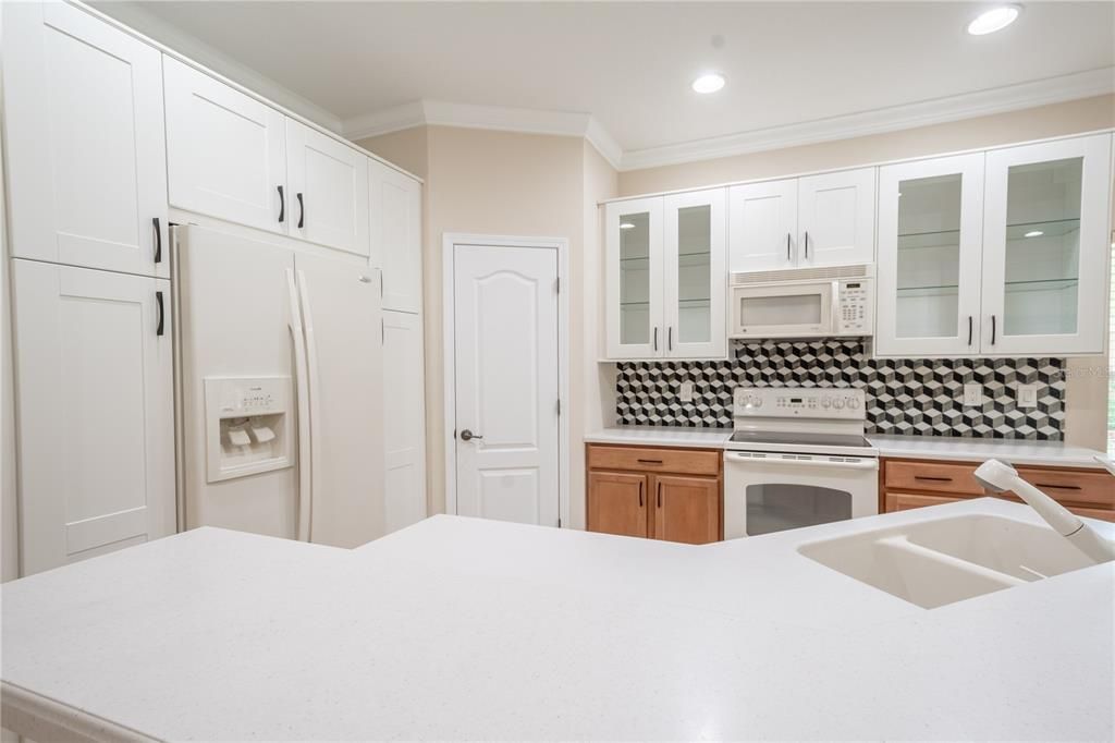 The kitchen features a range, a microwave and a French door refrigerator with water dispenser and ice maker.