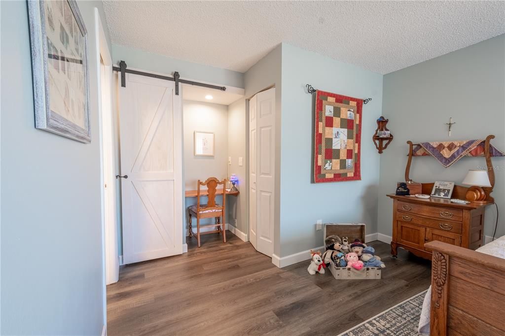 The spacious bedroom includes a unique closet desk/space with stylish barn door.