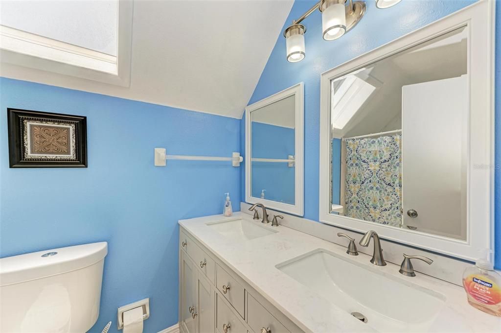 Hall bath has dual sinks and tub with shower