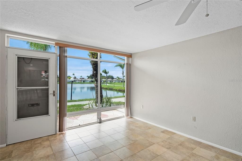 Living room has ceiling fan and ceramic tile flooring. The entire condo was just painted a neutral color.