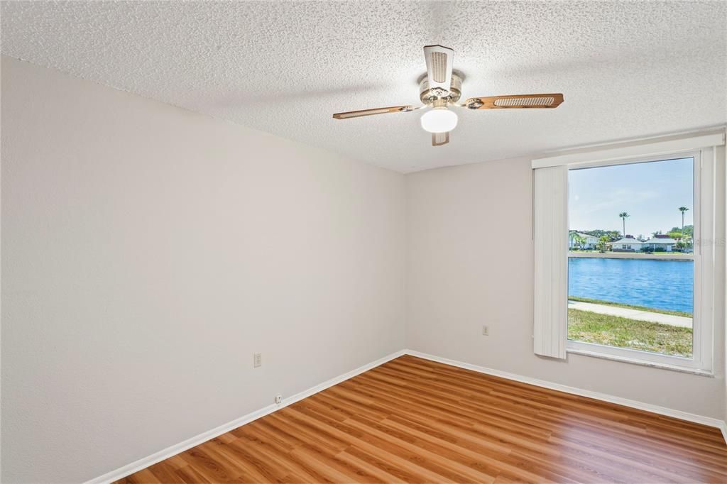 Bedroom has laminated flooring, ceiling fan, and a beautiful water view!