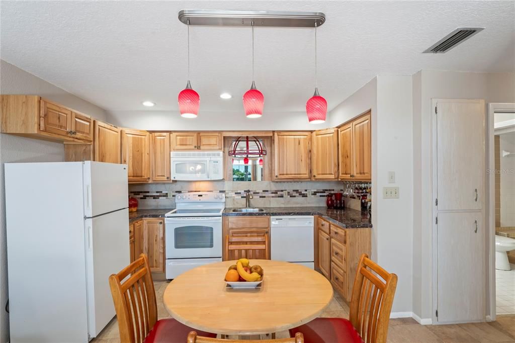 Kitchen and dining area has recessed lighting as well as drop down lighting.