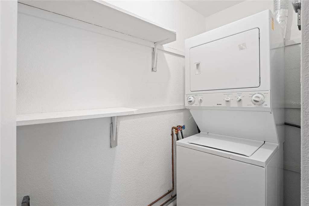 Utility room houses the hot water tank, and the washer and dryer which are included. Storage shelves are helpful as well.