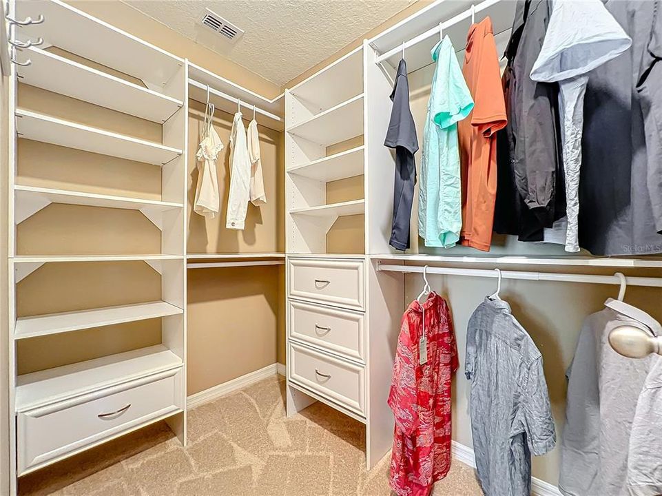 Walk-in Closet with closet system in the primary bedroom