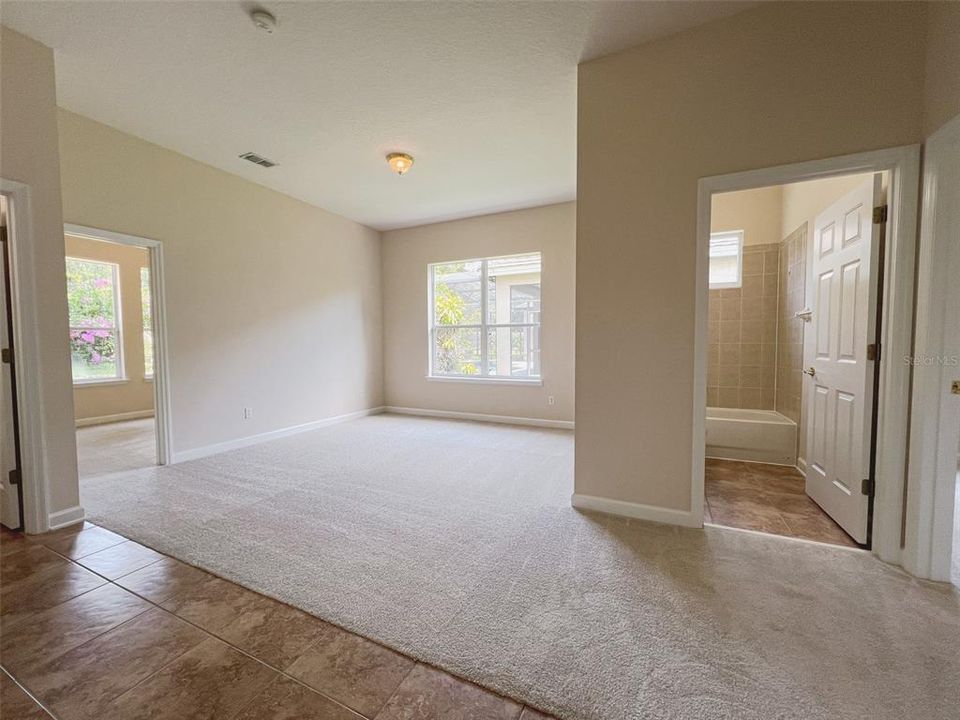 Spacious common area connecting from the kitchen featuring both the third and fourth bedrooms and their individual bathrooms