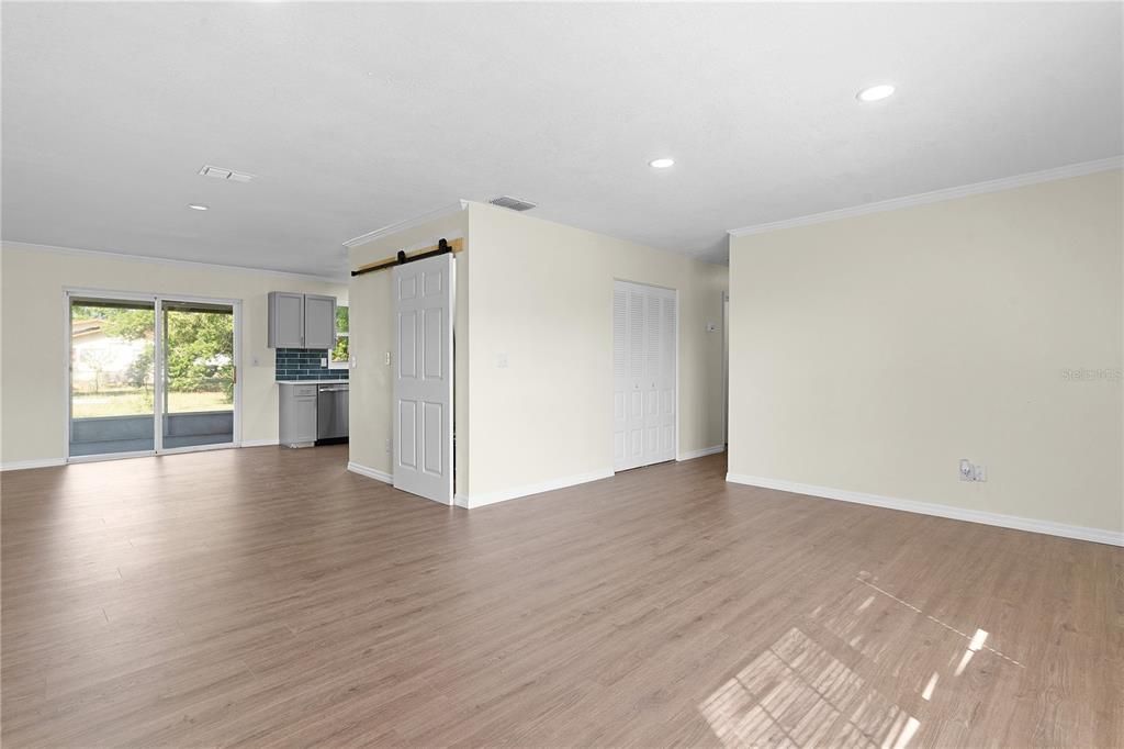 From the front wall of the living room, barn door to laundry room, and the mechanical closet (water heater and AC) at the beginning of the hallway