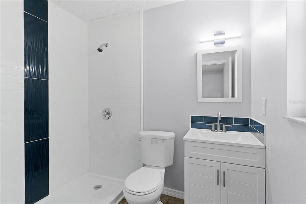 Primary bathroom with walk-in shower and tiled shower surround