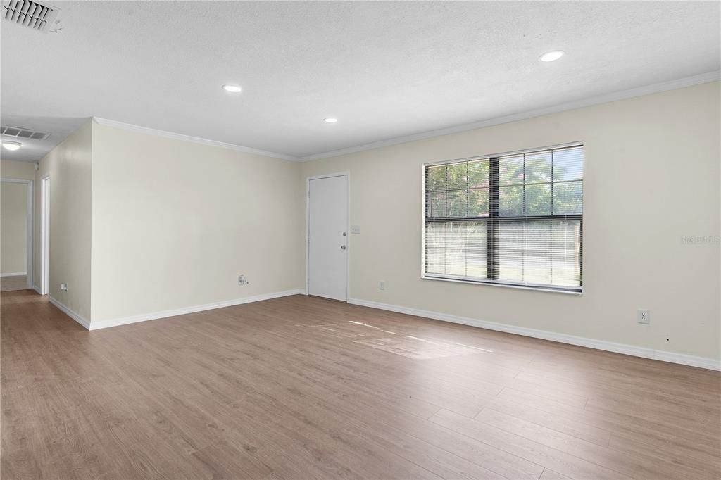 Spacious living room with front door in the center of the picture