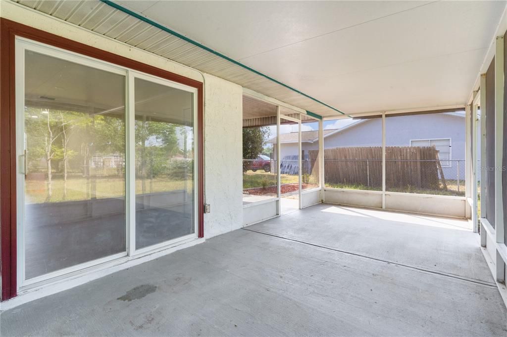 Screened lanai with sliding doors into the house and doorway to the carport on the far left, doorway to the back yard on the right