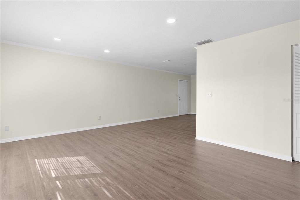 Looking from the front entry door across the living room (side entry door from carport is in the background)