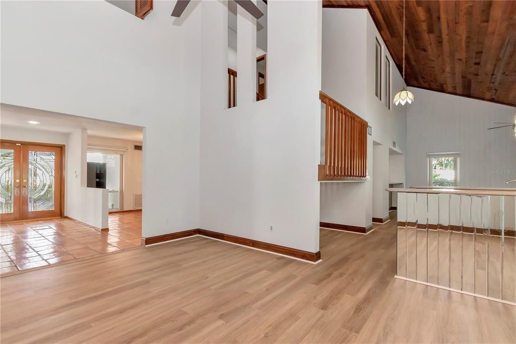 Wet Bar with Quartz Countertops, Sink and Storage Cabinets and Drawers connects Living and Family Room under Vaulted Ceilings with New Paint, New Vinyl Flooring and Hurricane-Rated Windows