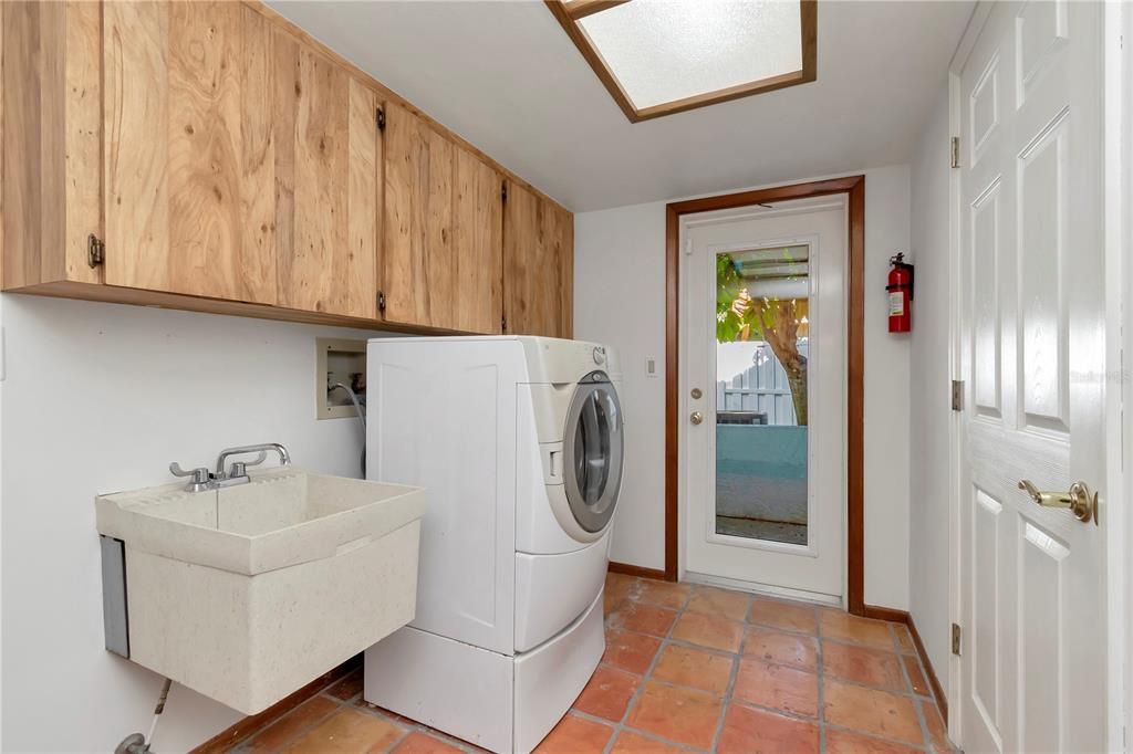 Laundry Room with New Paint, Utility Sink, Storage, Washer and Tile with Glass Exterior Door leading to AC Condensers (2019/2022)
