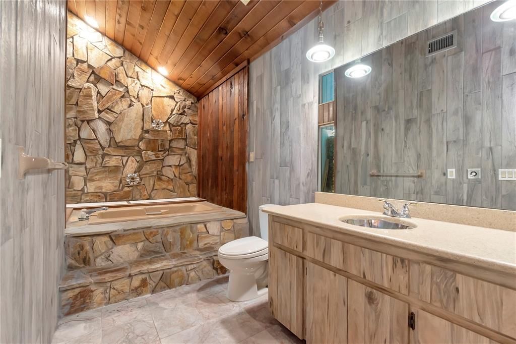Primary Bathroom with Garden Tub, Vanity with Quartz Countertops and Tile Floor