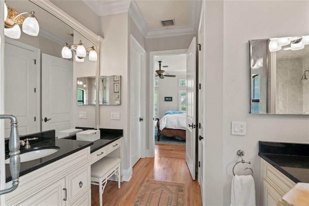 Primary bathroom with dual sinks, vanity, toilet closet and walk-in, glass-enclosed shower