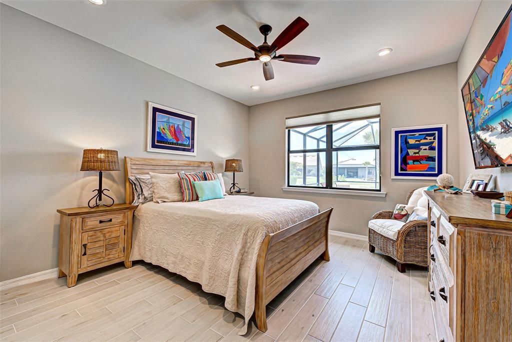 Owner's bedroom with lovely ceramic plank flooring, ceiling fan and extra lighting in ceiling.