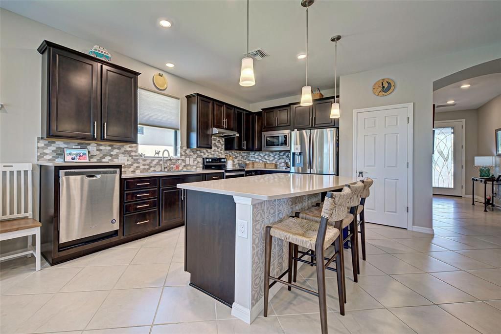 Custom Ceramic tiles added to front of kitchen Island. Raised dishwasher is a back saver!. Light added over sink. Glass added to front door is impact glass and brightens up the walkway.