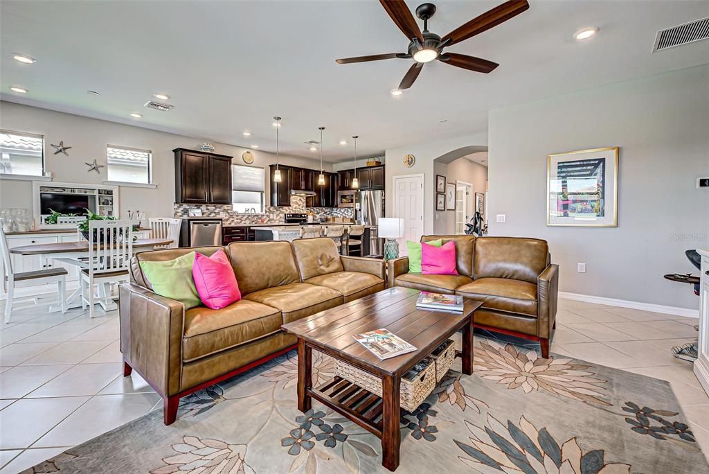 Gathering room with ceiling fan and extra lighting.