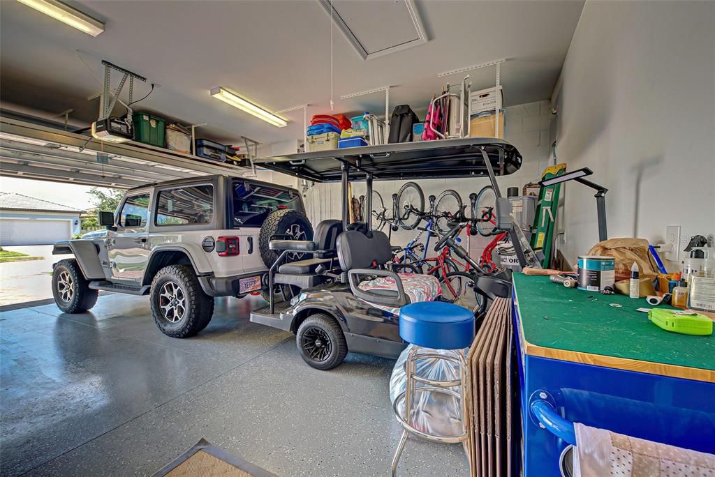 Garage can fit 2 cars and a golf cart plus has pull down stair way and suspended shelves for added storage.