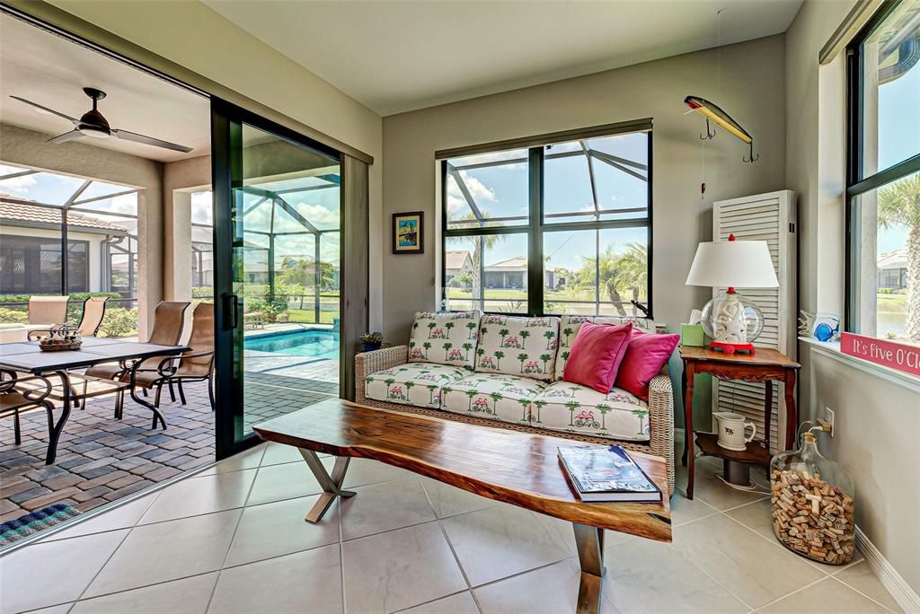 Sunroom slider leads to covered lanai area and pool.